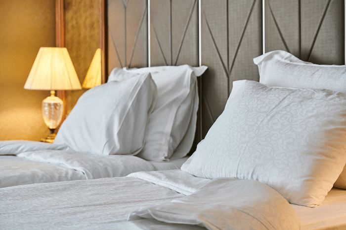 Duas camas de solteiro com dois travesseiros brancos em cada uma.